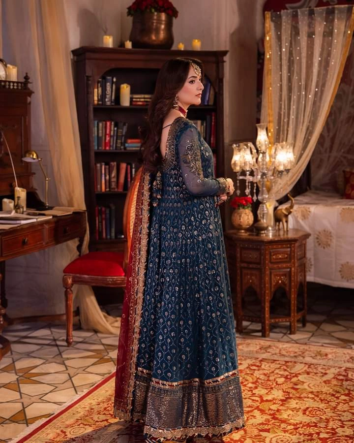 Chandni Raatein Collection by BASITKK Launching on 10th Sep at 6 PM
AJCR-06 | 3-PCS | Unstitched | Rs. 15550

Swathed in the opulence of regality, this teal hued outfit exudes an aura of understated elegance. The intricately embroidered Angrakha, a treasu